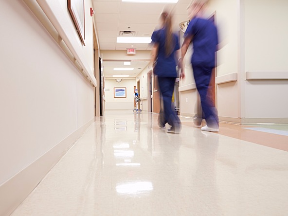 healthcare workers walking along a hospital corridor